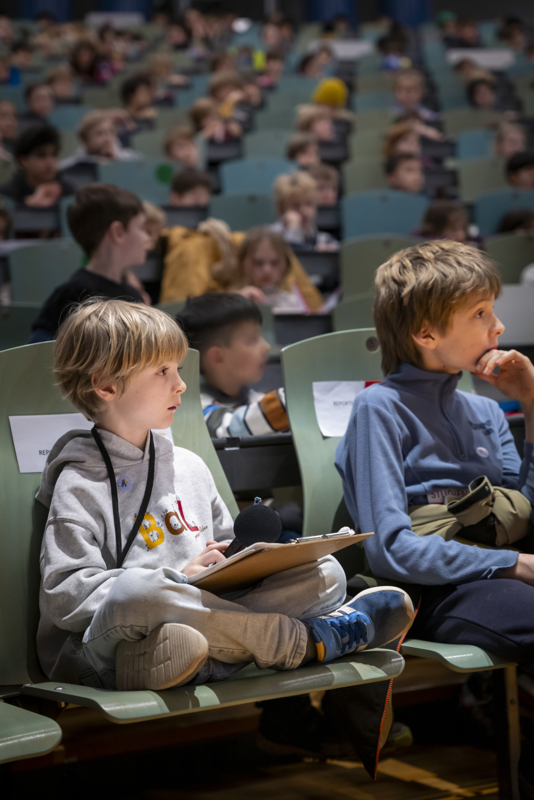 20250110_TUM_KinderUni_Preiss_SK1000515 Kinder im Hörsaal hören und sehen aufmerksam zu.